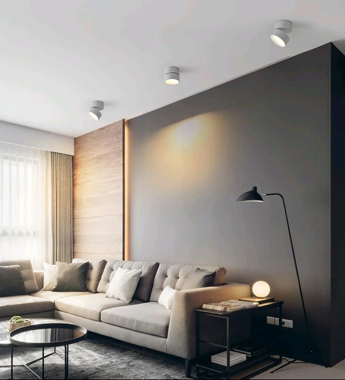 ห้องนั่งเล่นที่ใช้โคมส่องเพดานให้แสงสีเหลืองอุ่นสาดลงผนัง